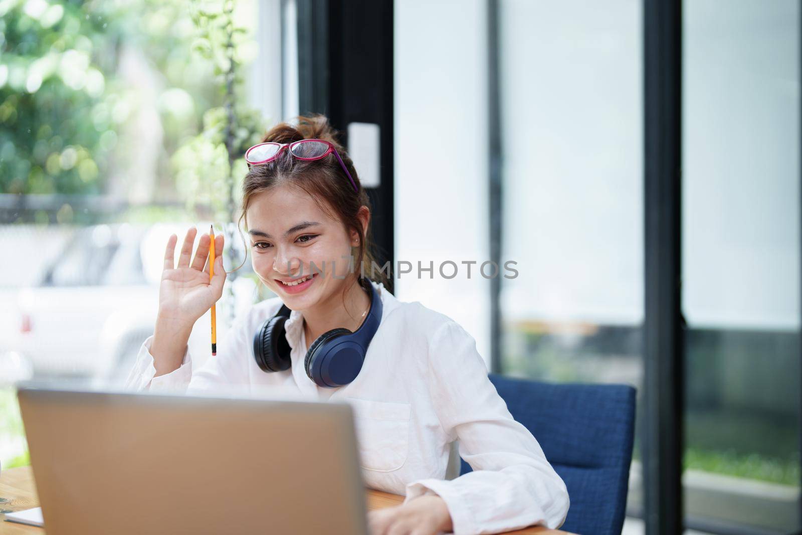 Portrait of a beautiful woman using a computer and earphone during a video conference