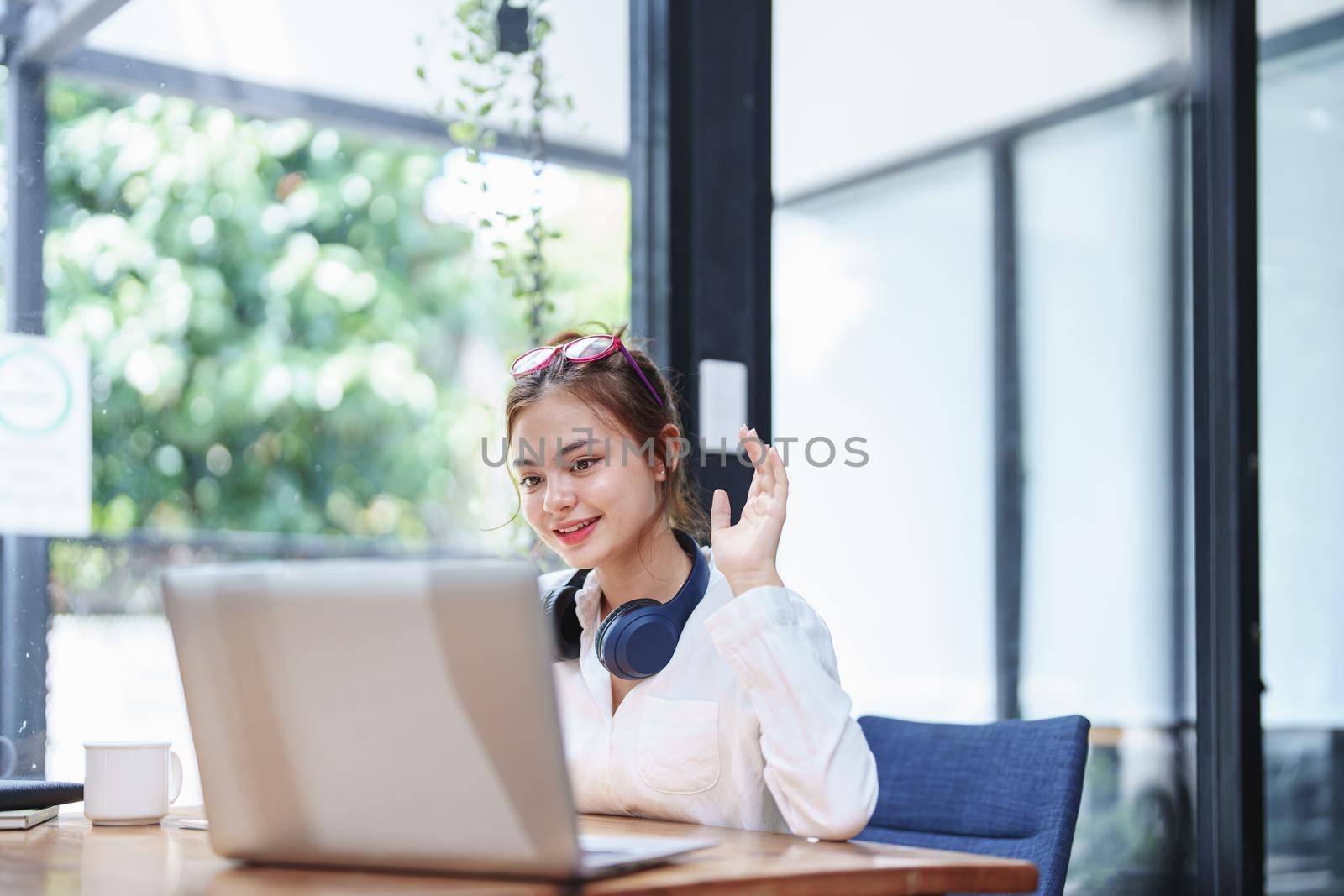 Portrait of a beautiful woman using a computer and a notebook during a video conference