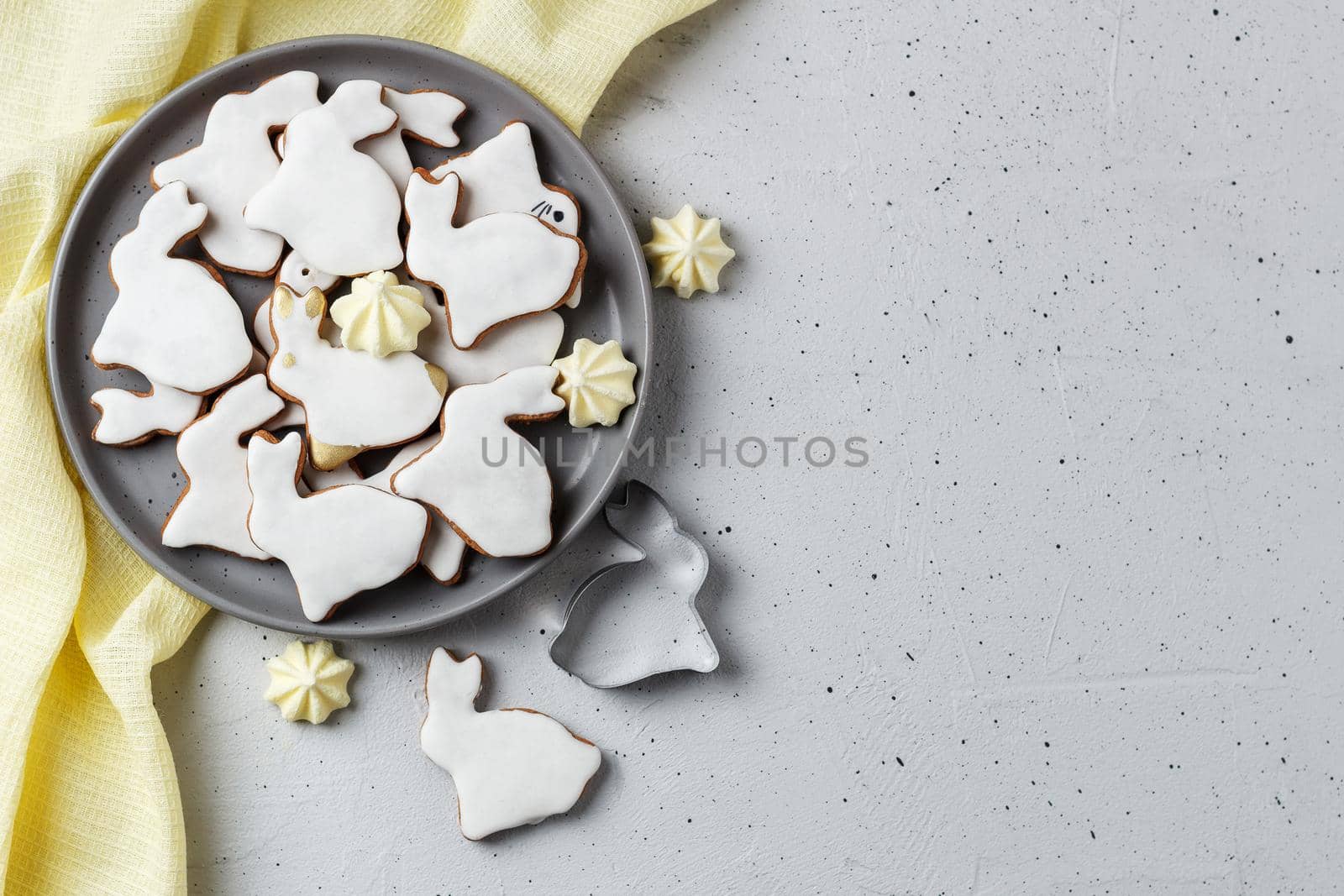 Easter cookies in the form of a rabbit on a gray plate with yellow textiles on a gray background. copy space by lara29