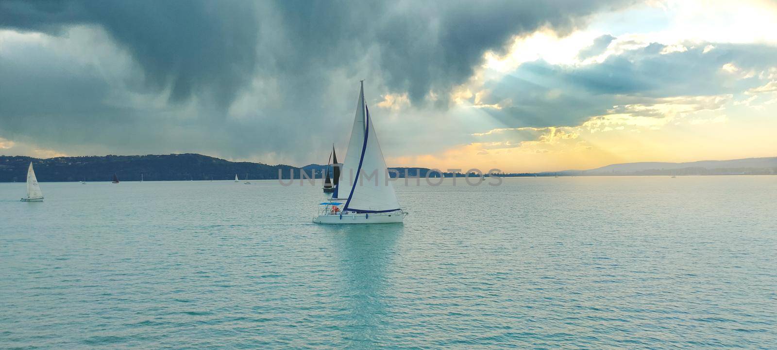 Sailboat in the sea in the evening with cinematic sunset. High quality photo