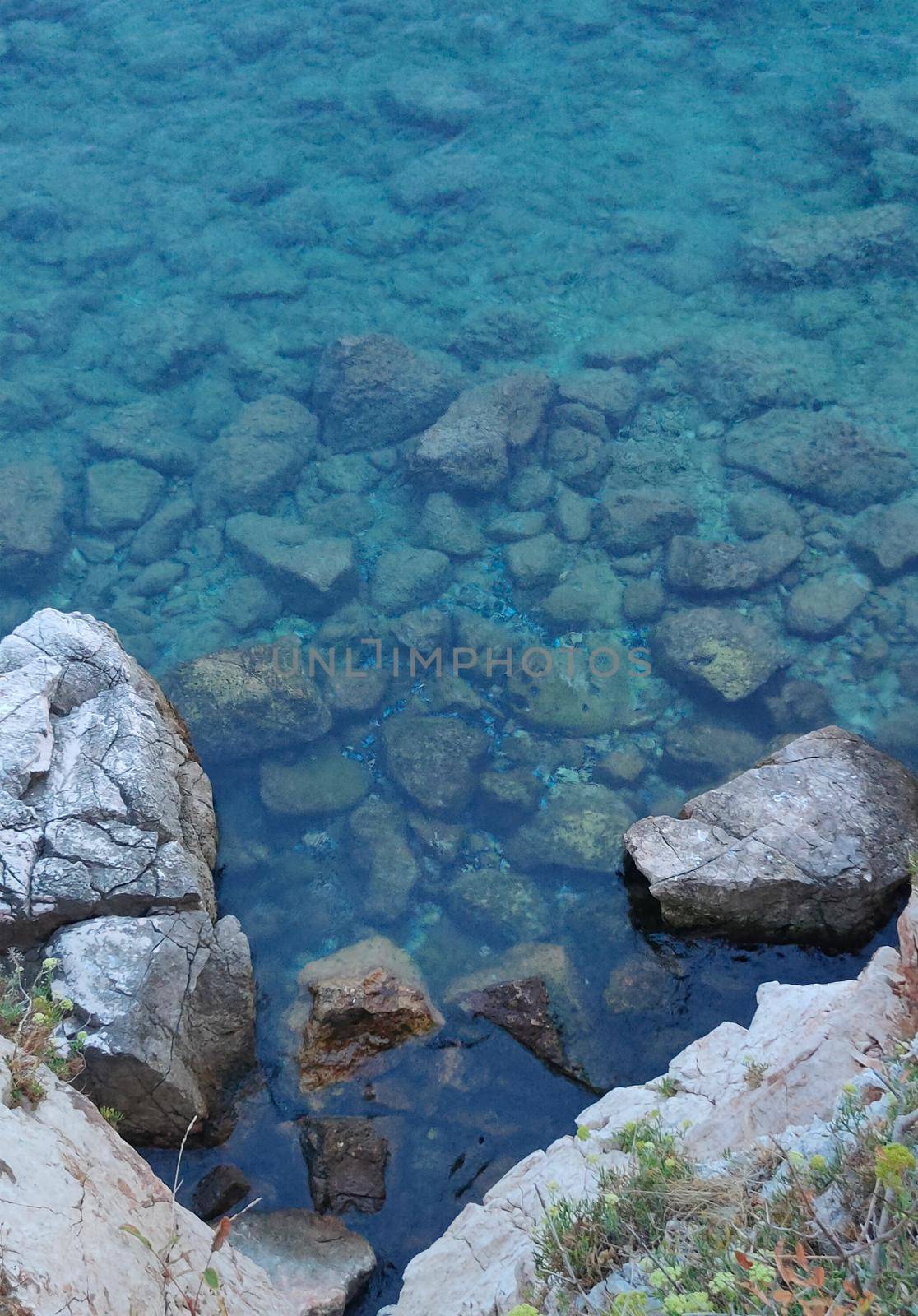 sea water with sunlight on turquoise pebbles background. High quality photo