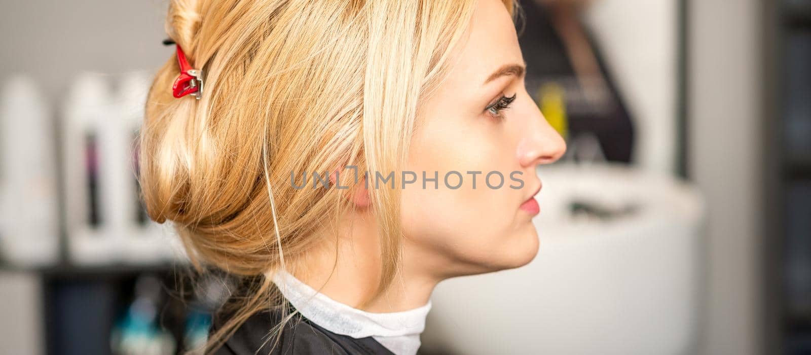 Gorgeous profile of caucasian beauty blonde woman with beautiful hairstyle over hair salon background