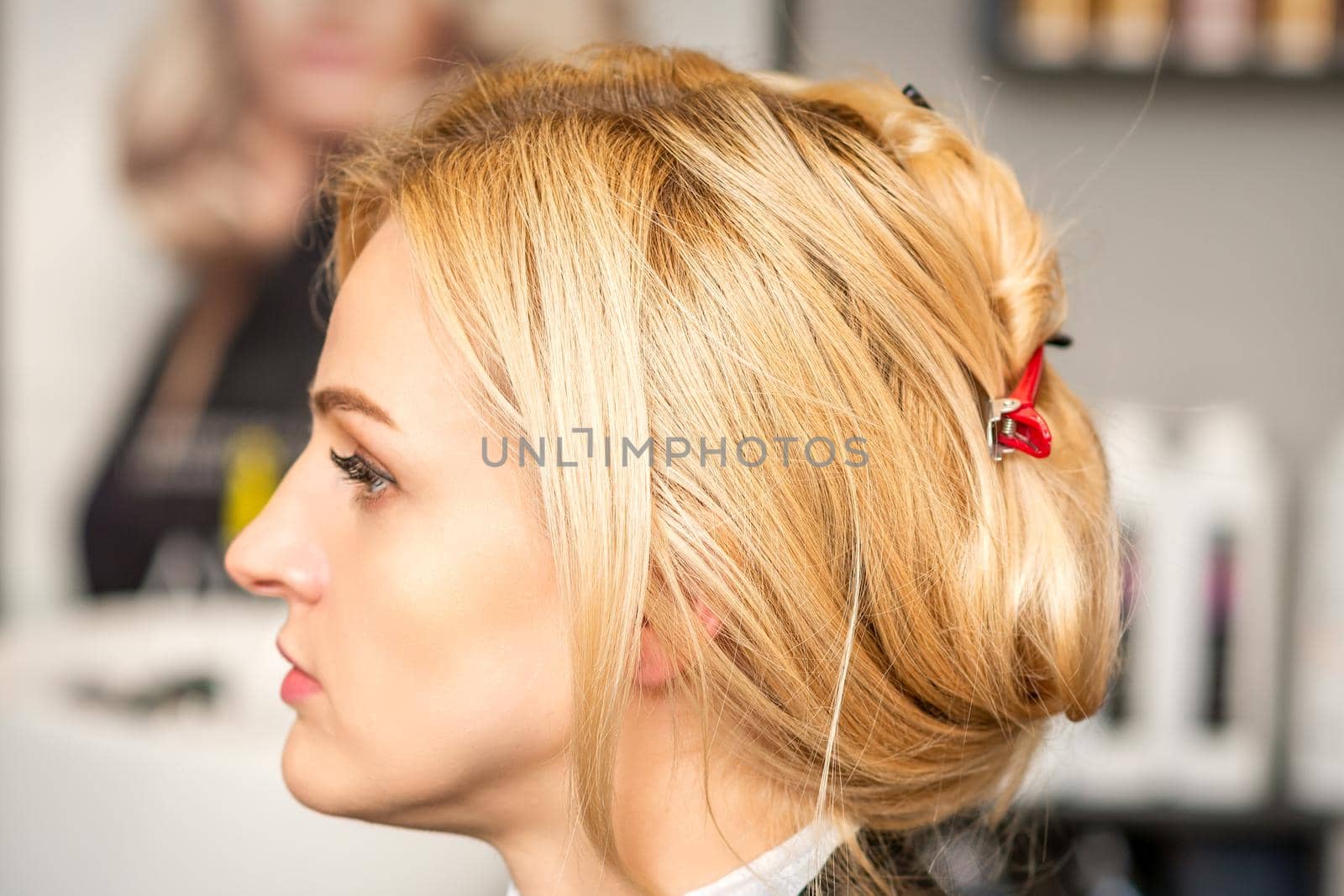 Gorgeous profile of caucasian beauty blonde woman with beautiful hairstyle over hair salon background