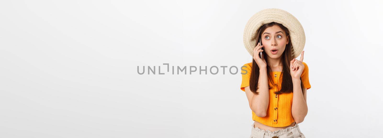 Picture of surprised voyage girl looking shock while holding phone in hands isolated over grey background.