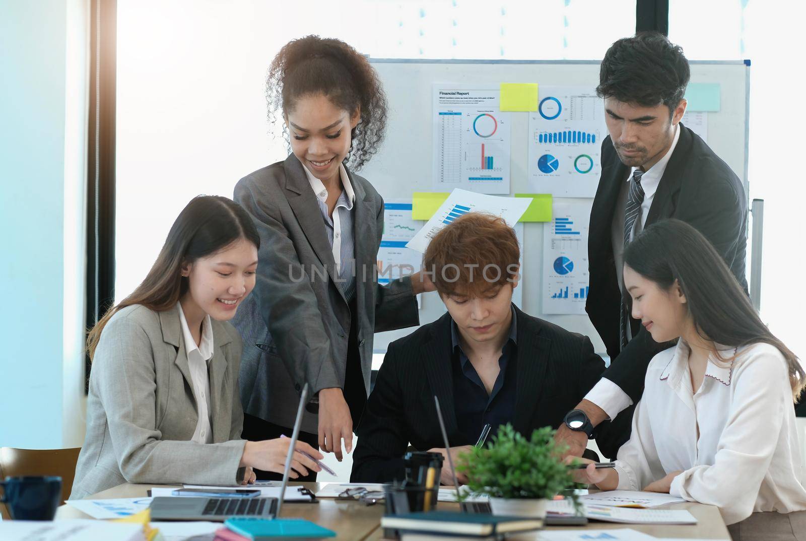 Asian business woman leader workers a paper business plan in a group meeting. Emphasis on female mentor teachers Train a variety of employees in corporate office workshops. by wichayada