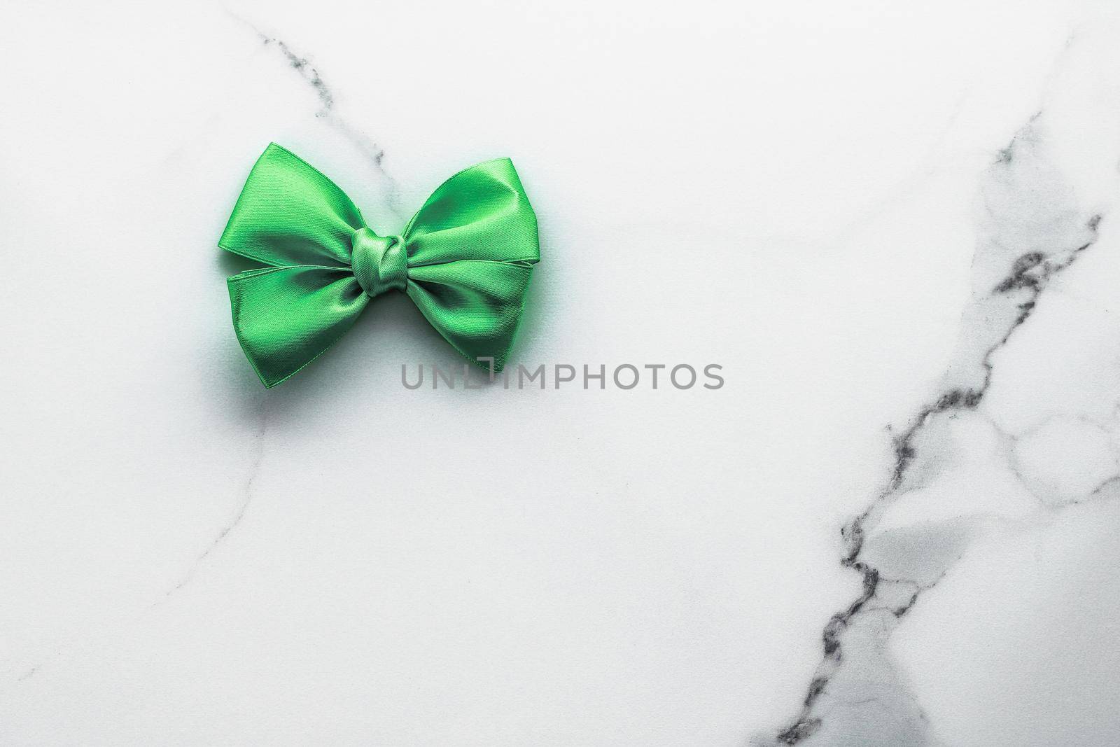 Decorative, birthday and art branding concept - Green silk ribbon and bow on marble background, St Patricks day present or Christmas glamour gift decor for luxury digital brand, holiday flatlay design