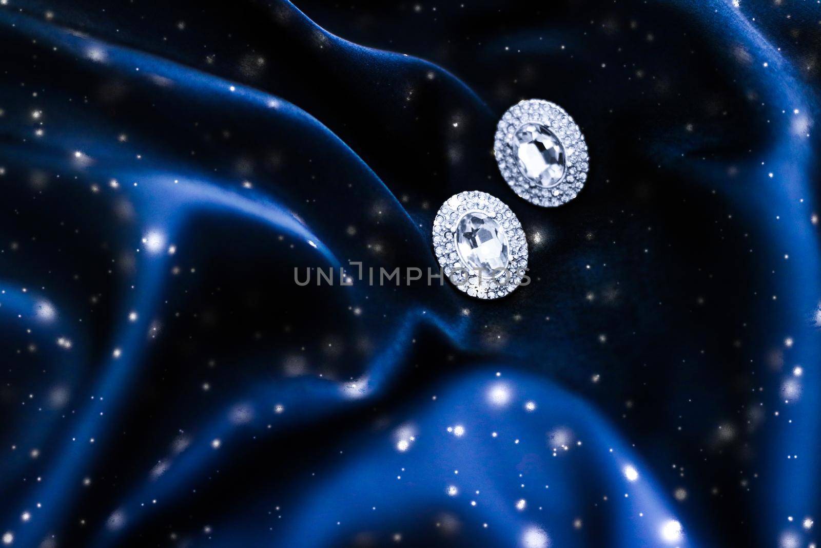 Luxury diamond earrings on dark blue silk with snow glitter, holiday winter magic jewelery present by Anneleven