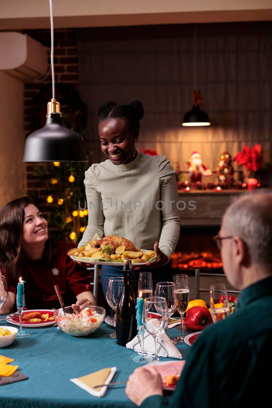 Family gathering at christmas festive dinner table by DCStudio