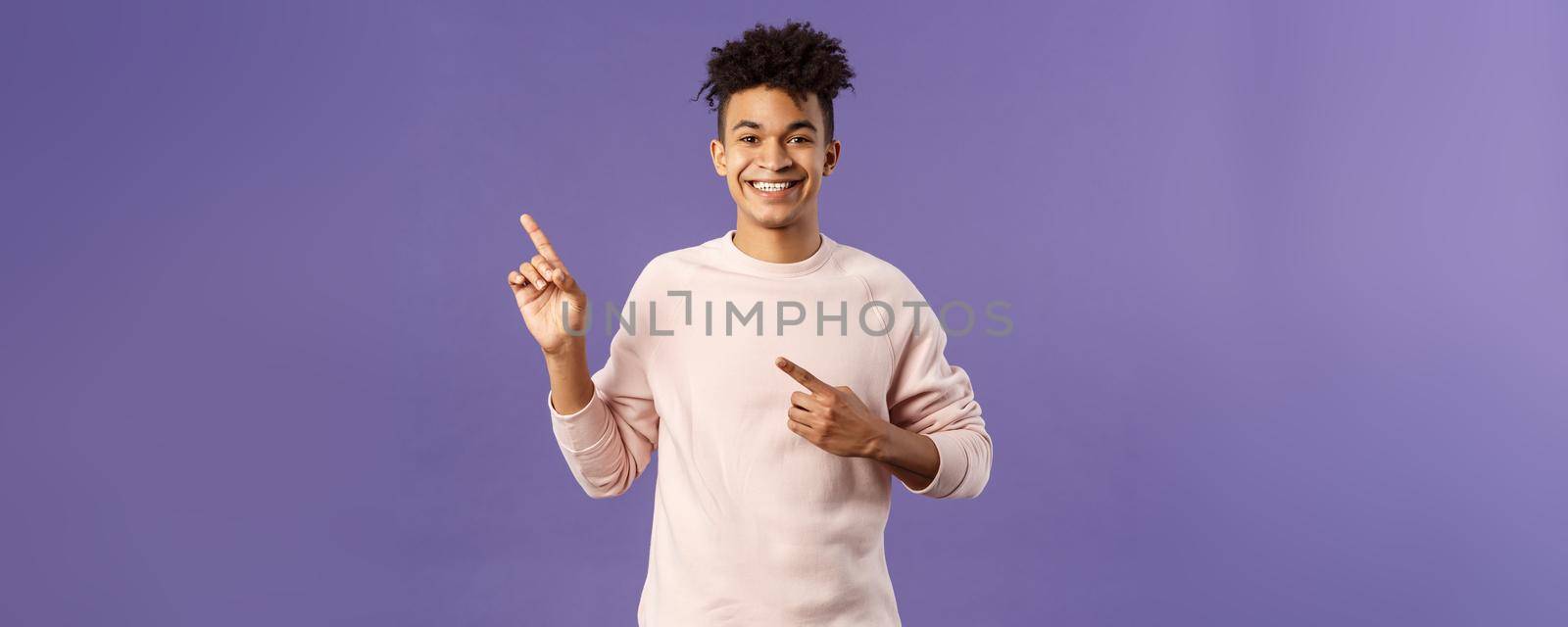 Portrait of cheerful, healthy smiling man pointing fingers upper left corner, recommending buy product, shop online, order delivery, advertisement and people concept, purple background by Benzoix