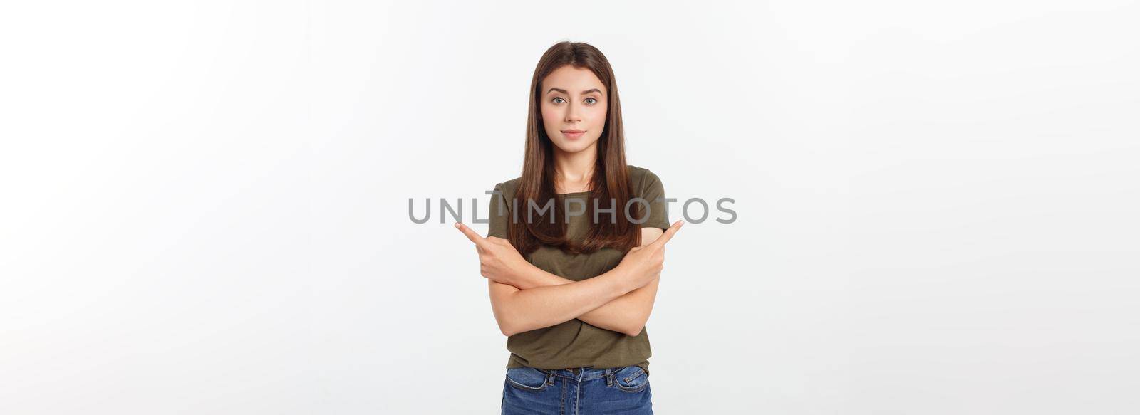 Portrait happy and surprised young lady standing isolated over grey background. Looking camera pointing