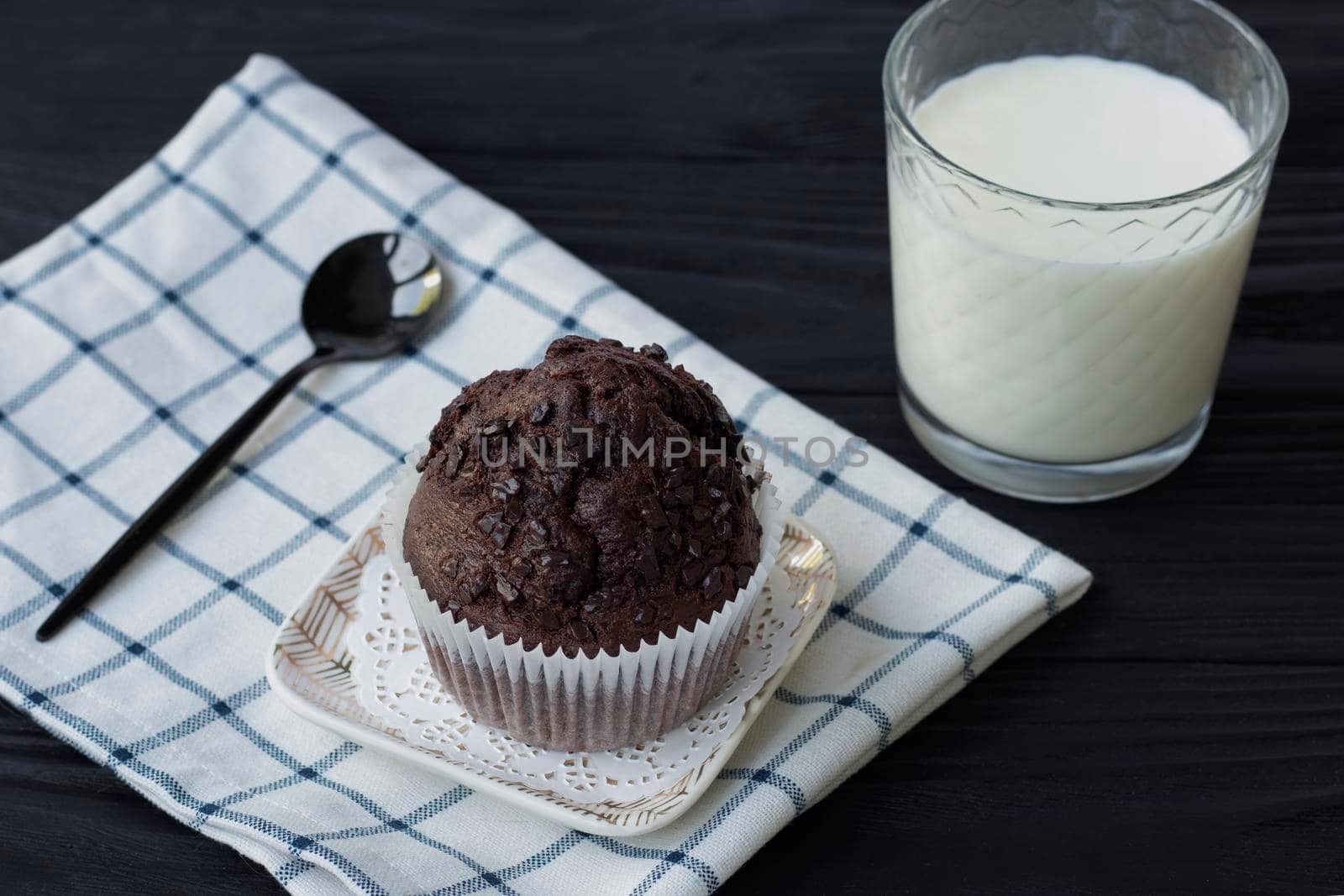 Homemade chocolate muffins or cake with a glass of milk. Place for text. Homemade or bakery pastries for breakfast or celebration. High quality photo