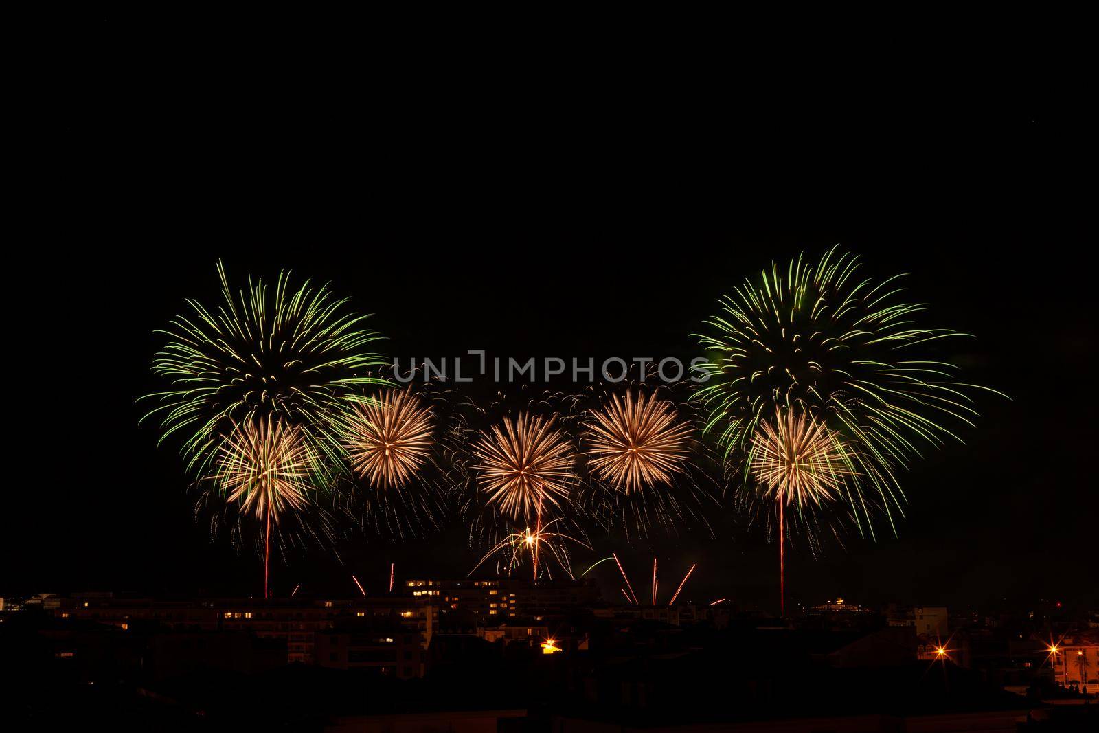 bright green and yellow fireworks in a night sky