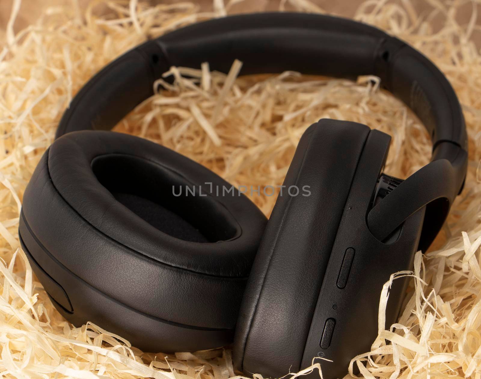 black stereo headphones in gift tinsel, paper shavings. High quality photo