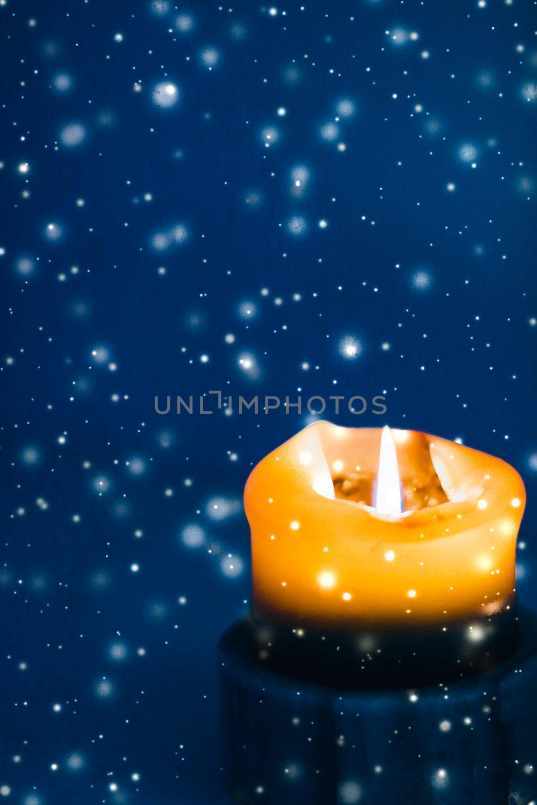 Happy holidays, greeting card and winter season concept - Yellow holiday candle on blue sparkling snowing background, luxury branding design for Christmas, New Years Eve and Valentines Day