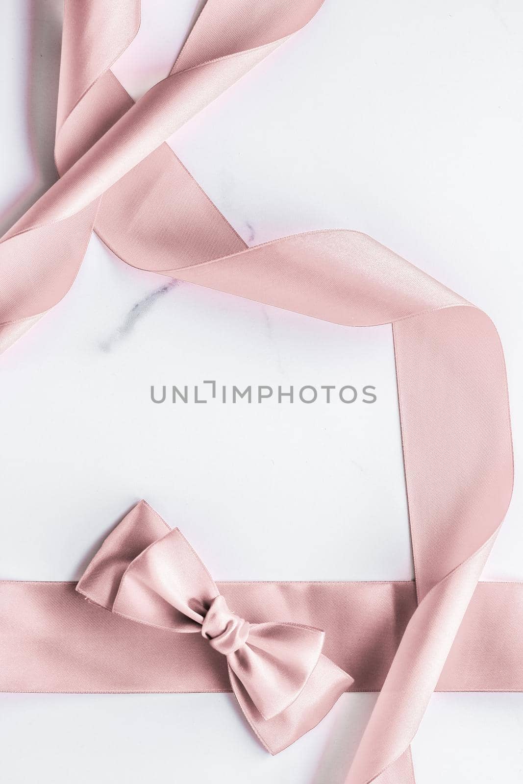 Beige silk ribbon and bow on marble background, glamour present mockup and fashion gift decoration for luxury beauty brand holiday flatlay design by Anneleven