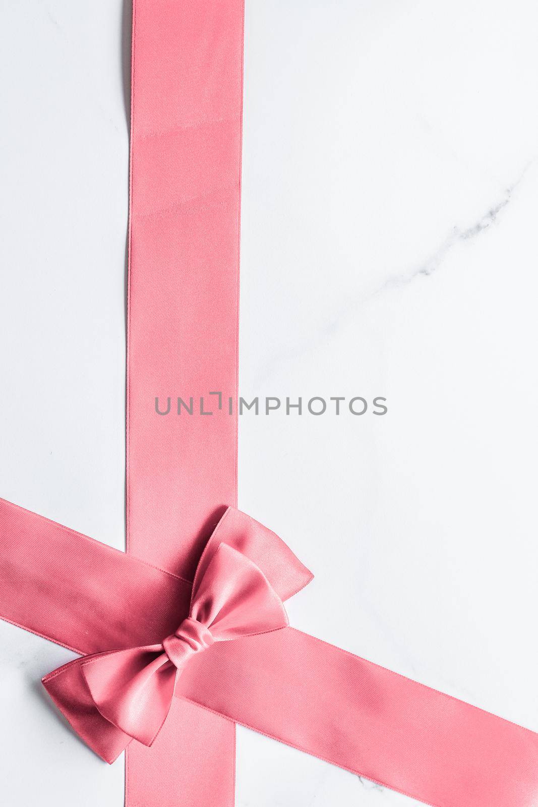 Birthday, wedding and girly branding concept - Coral silk ribbon and bow on marble background, girl baby shower present and glamour fashion gift decor for luxury beauty brand, holiday flatlay design