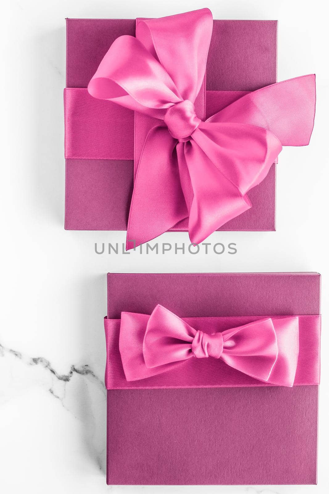 Pink gift box with silk bow on marble background, girl baby shower present and glamour fashion gift for luxury beauty brand, holiday flatlay art design by Anneleven