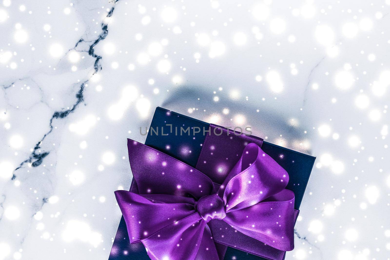 Winter holiday gift box with purple silk bow, snow glitter on marble background as Christmas and New Years presents for luxury beauty brand, flatlay design by Anneleven