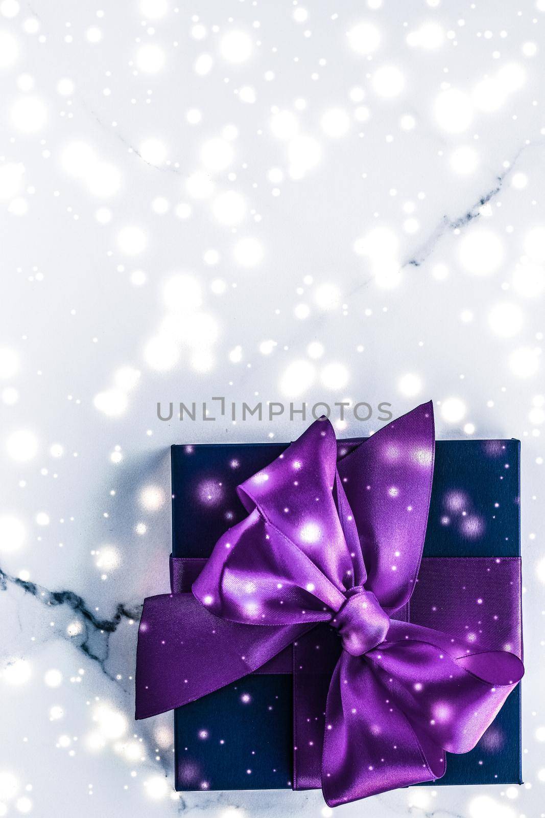 Winter holiday gift box with purple silk bow, snow glitter on marble background as Christmas and New Years presents for luxury beauty brand, flatlay design by Anneleven