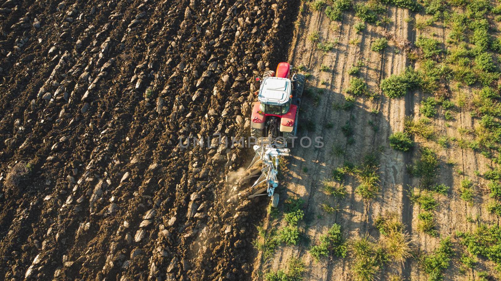 Aerial view with drone of tractor plowing the land in the countryside.