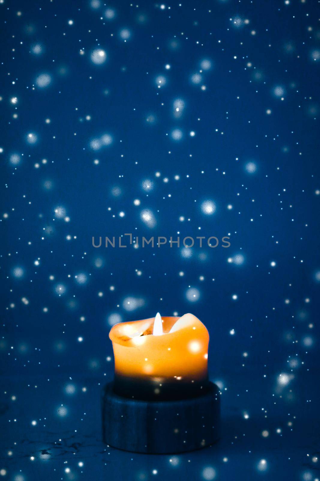 Happy holidays, greeting card and winter season concept - Yellow holiday candle on blue sparkling snowing background, luxury branding design for Christmas, New Years Eve and Valentines Day