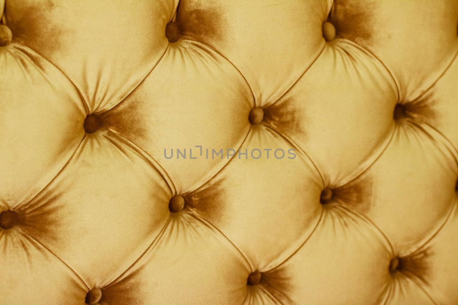 Golden luxury velour quilted sofa upholstery with buttons, elegant home decor texture and background by Anneleven