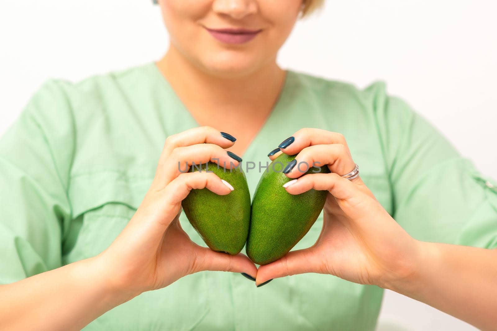 Female nutritionist doctor holding organic avocado fruit. Healthy lifestyle concept