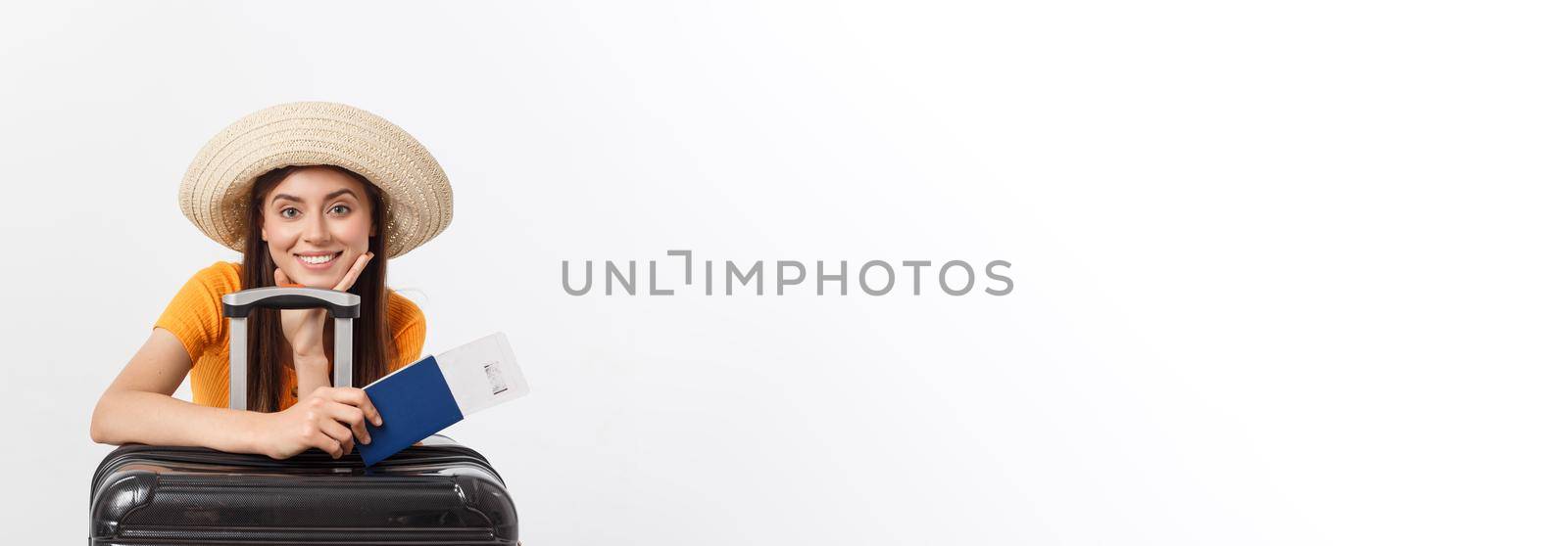 Travel concept. Studio portrait of pretty young woman holding passport and luggage. Isolated on white.