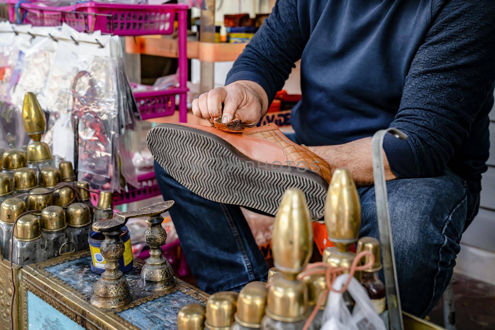 Man cleans shoes with help of shoe polish on street, close up. Ancient method of shoe cleaning.