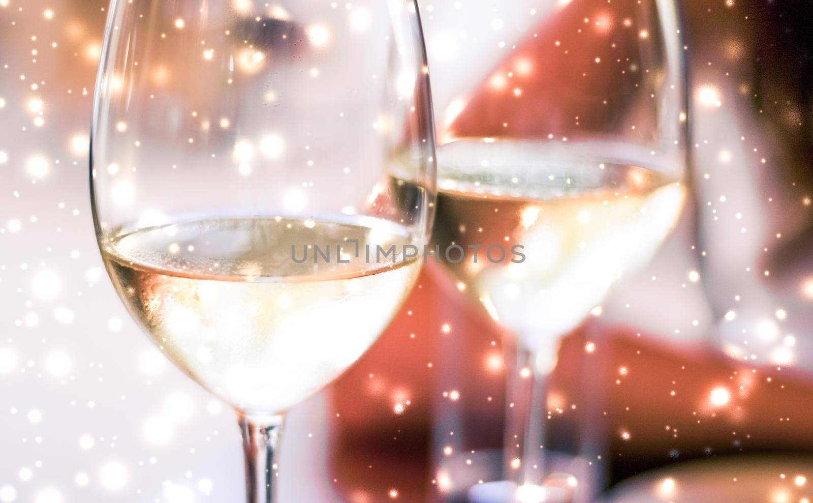 Winter holiday glasses of white wine and glowing snow on background, Christmas time romance by Anneleven
