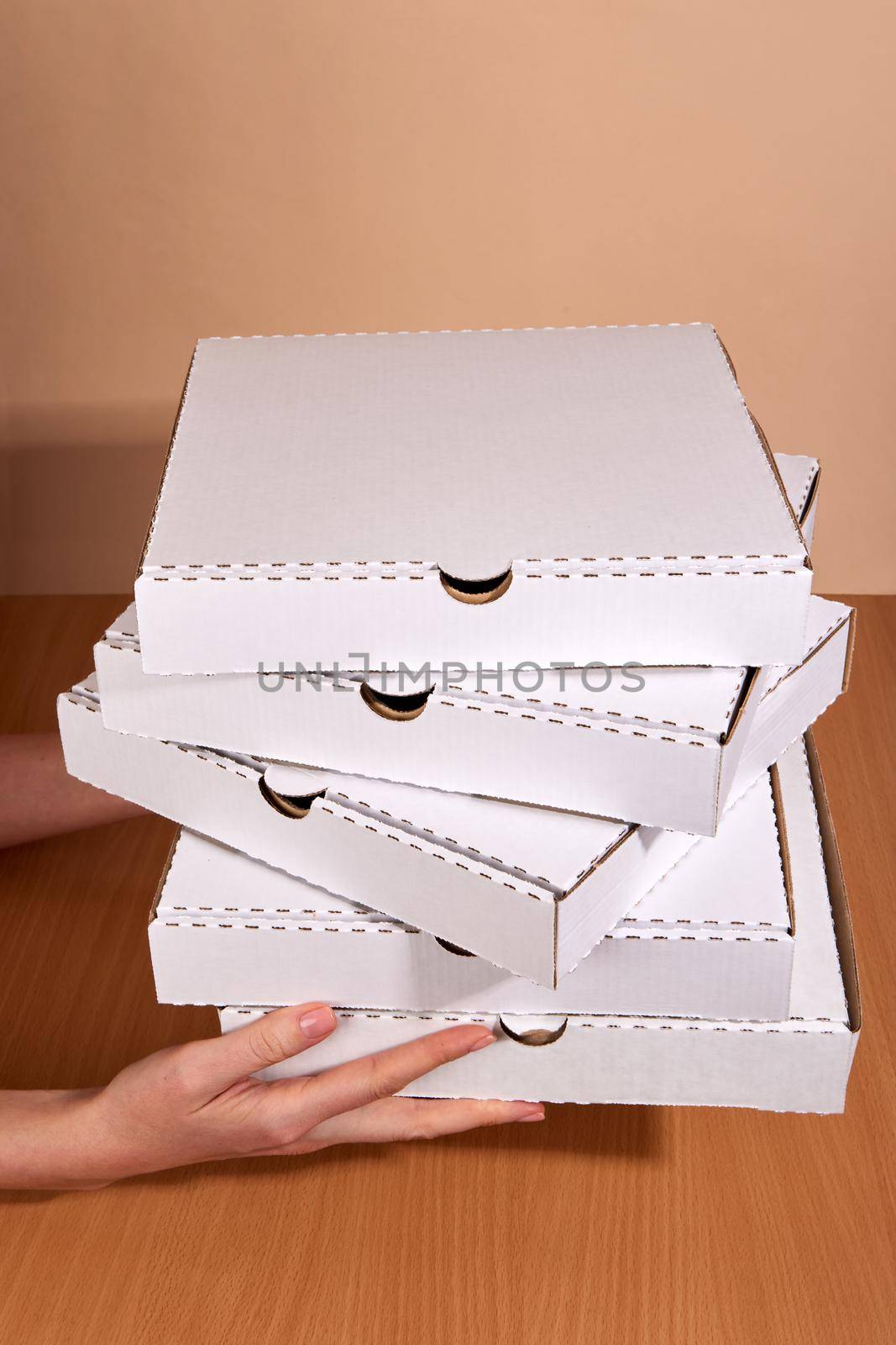 Delivery hands hold cardboard boxes, natural white color, eco-friendly and biodegradable products, boxes for the delivery of food and gifts, confectionery and food