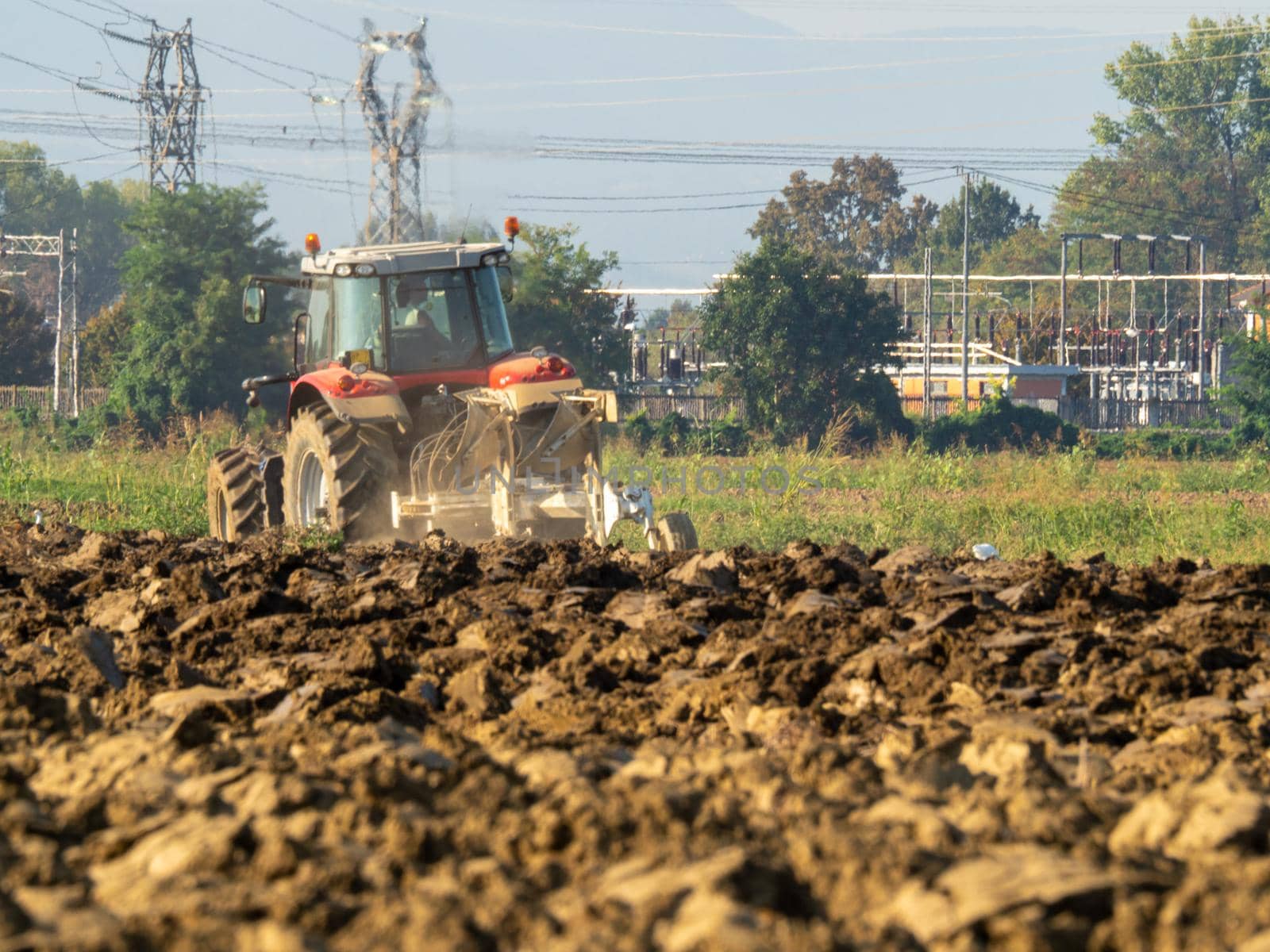 farmer with tractor plowing the land in the countryside.