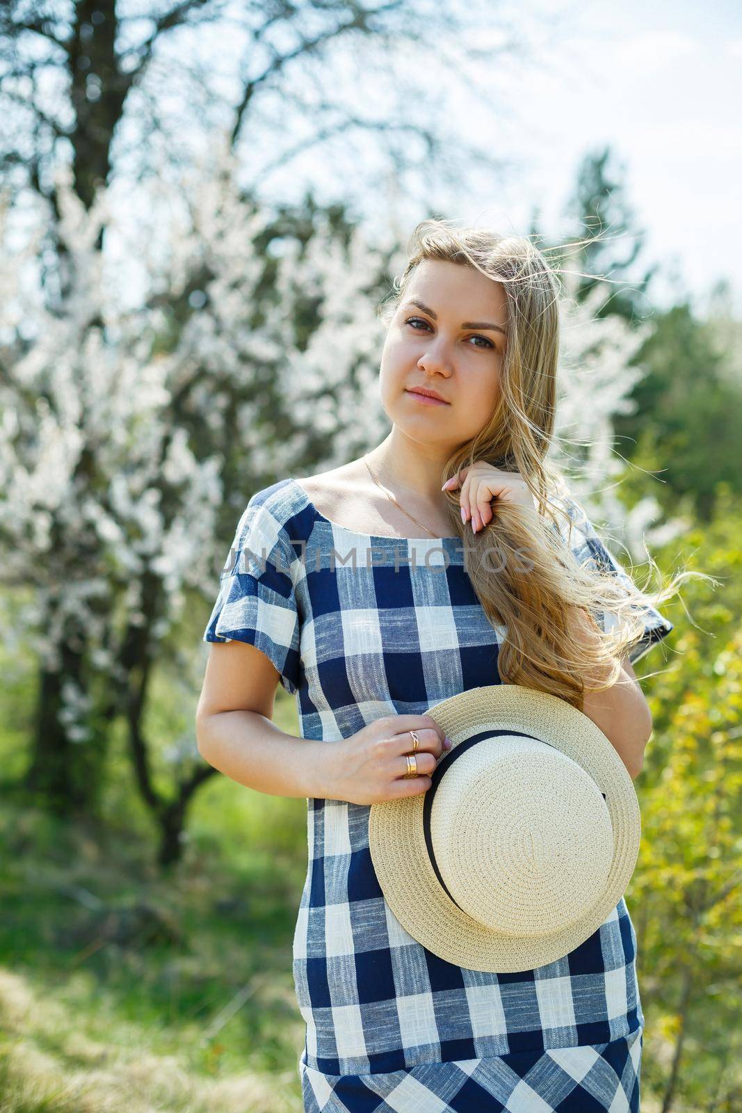 beautiful girl in a dress walking in the spring forest where the trees bloom