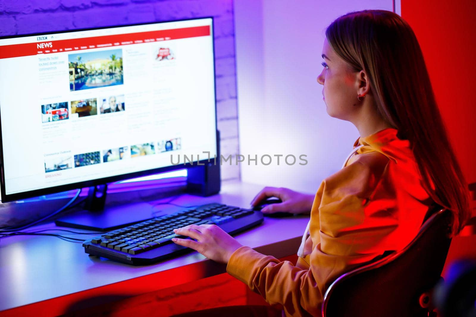 girl freelancer looks on the computer screen news about forest fires and the virus COVID-19