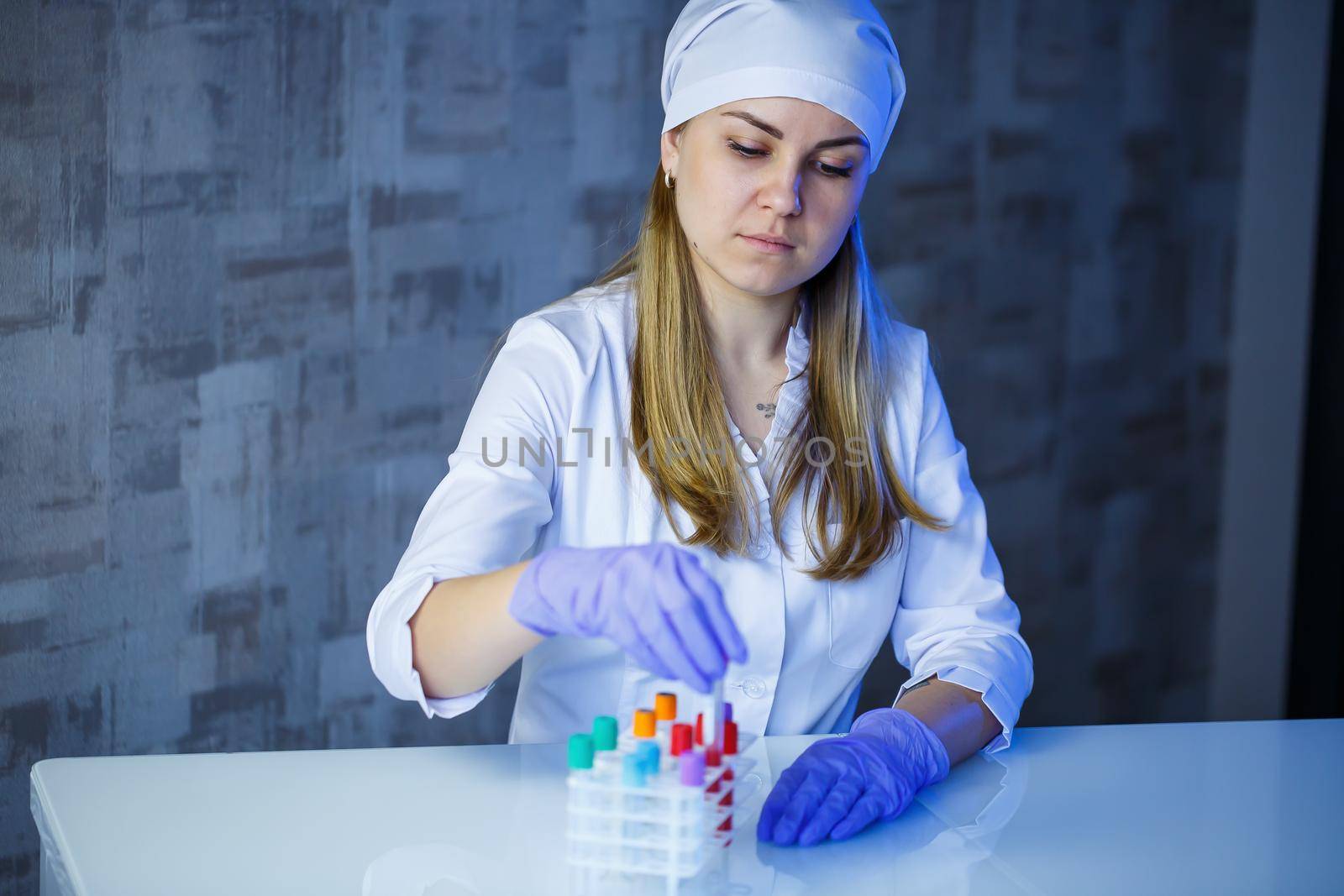 A medical professional, laboratory assistant, doctor performs an analysis in a laboratory, uses test tubes, a pipette and a petri dish for the presence of bacteria in the human body. Selective focus