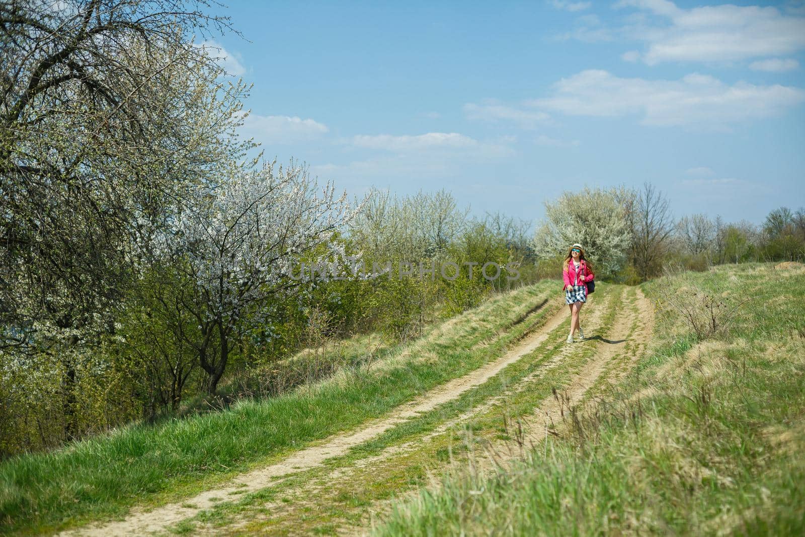 beautiful girl in a dress walking in the spring forest where the trees bloom