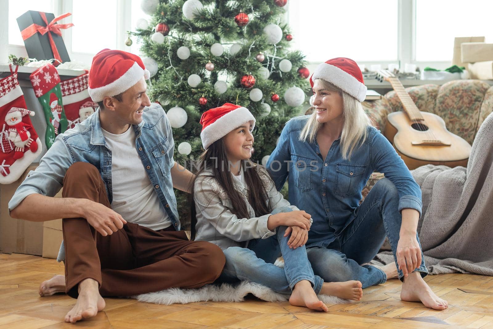 happy family mother, father and child daughter near Christmas tree at home.