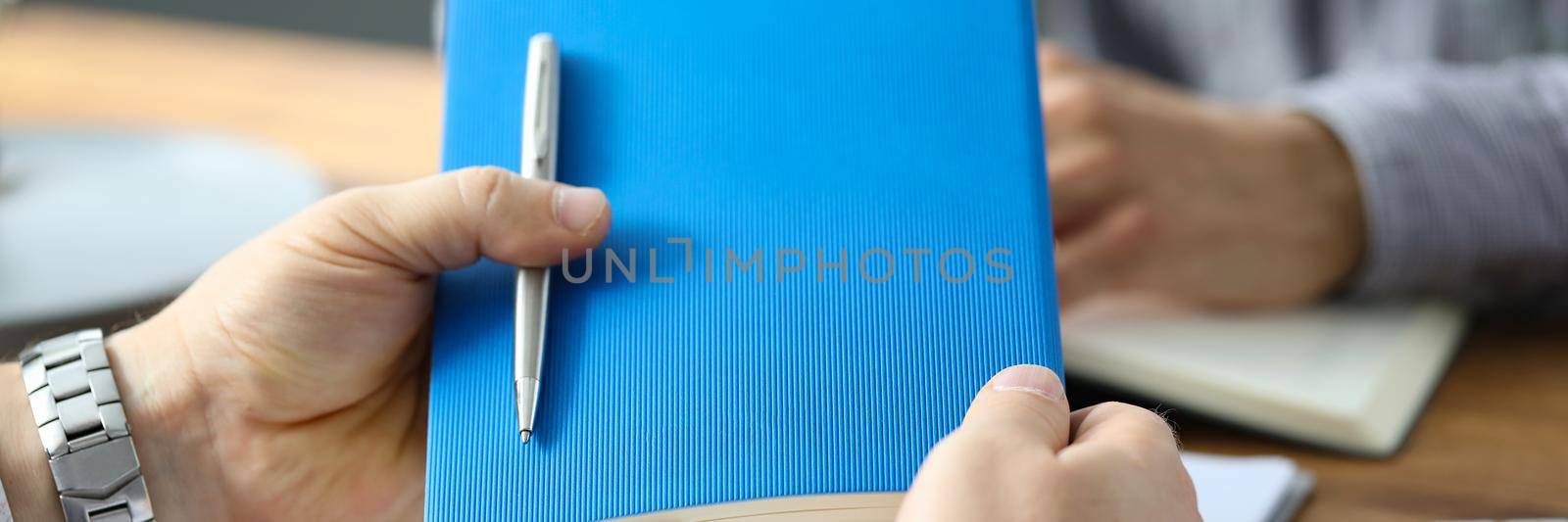 Businessman holding diary with pen at marketing meeting. Business analytics and statistics concept