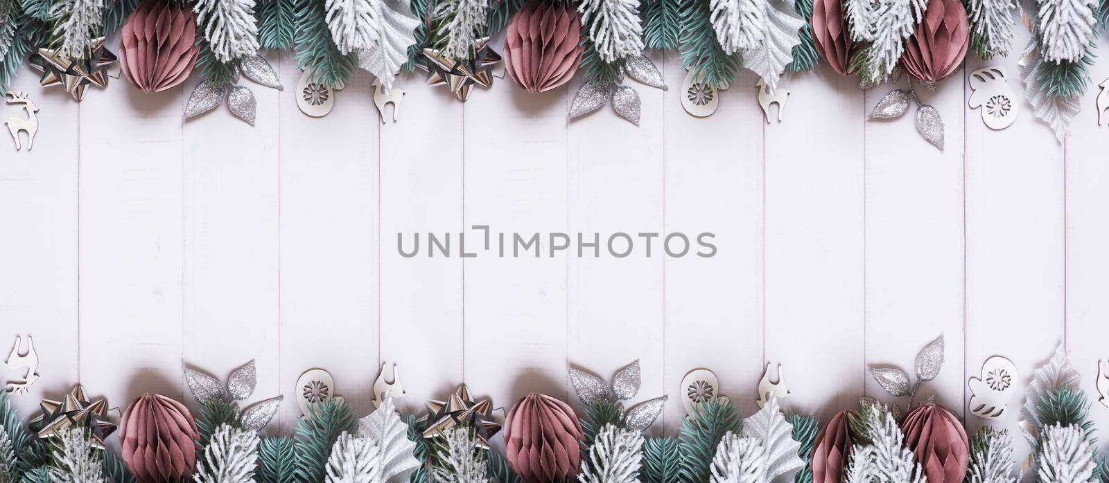 Christmas banner with flat lay snow pine trees, paper and wooden Christmas toys on wooden background by ssvimaliss
