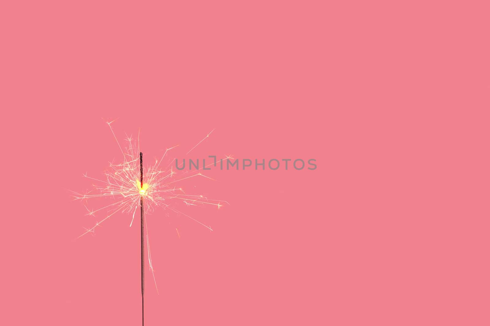 Bengal fire on a colored background. Minimalistic christmas festive concept with copy space. High quality photo