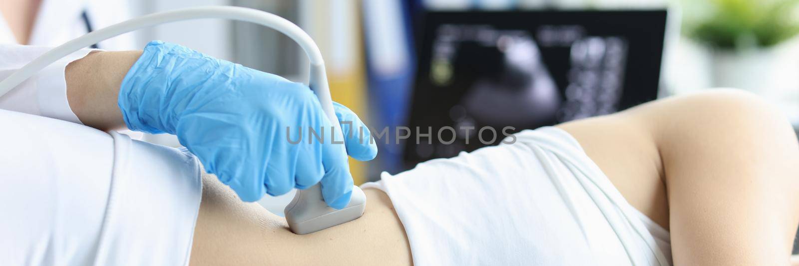 Doctor making ultrasound of kidneys to patient in clinic closeup. Diagnosis and treatment of urolithiasis concept