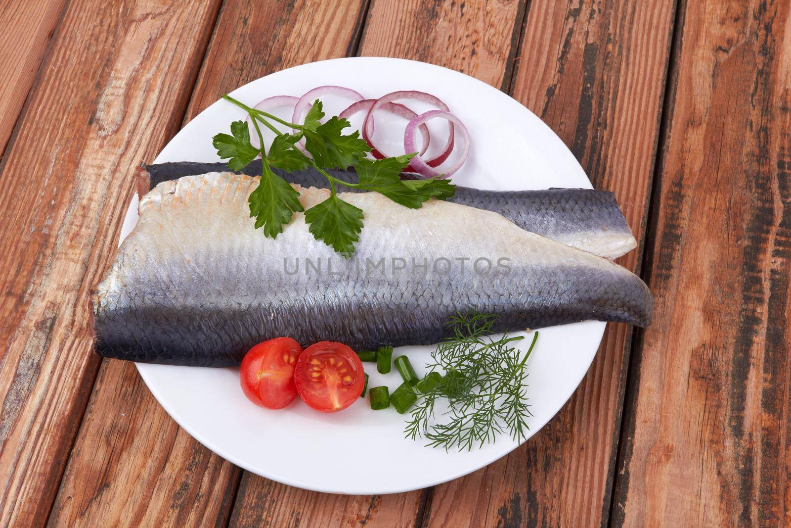 Slices of herring fish isolated on a wooden background