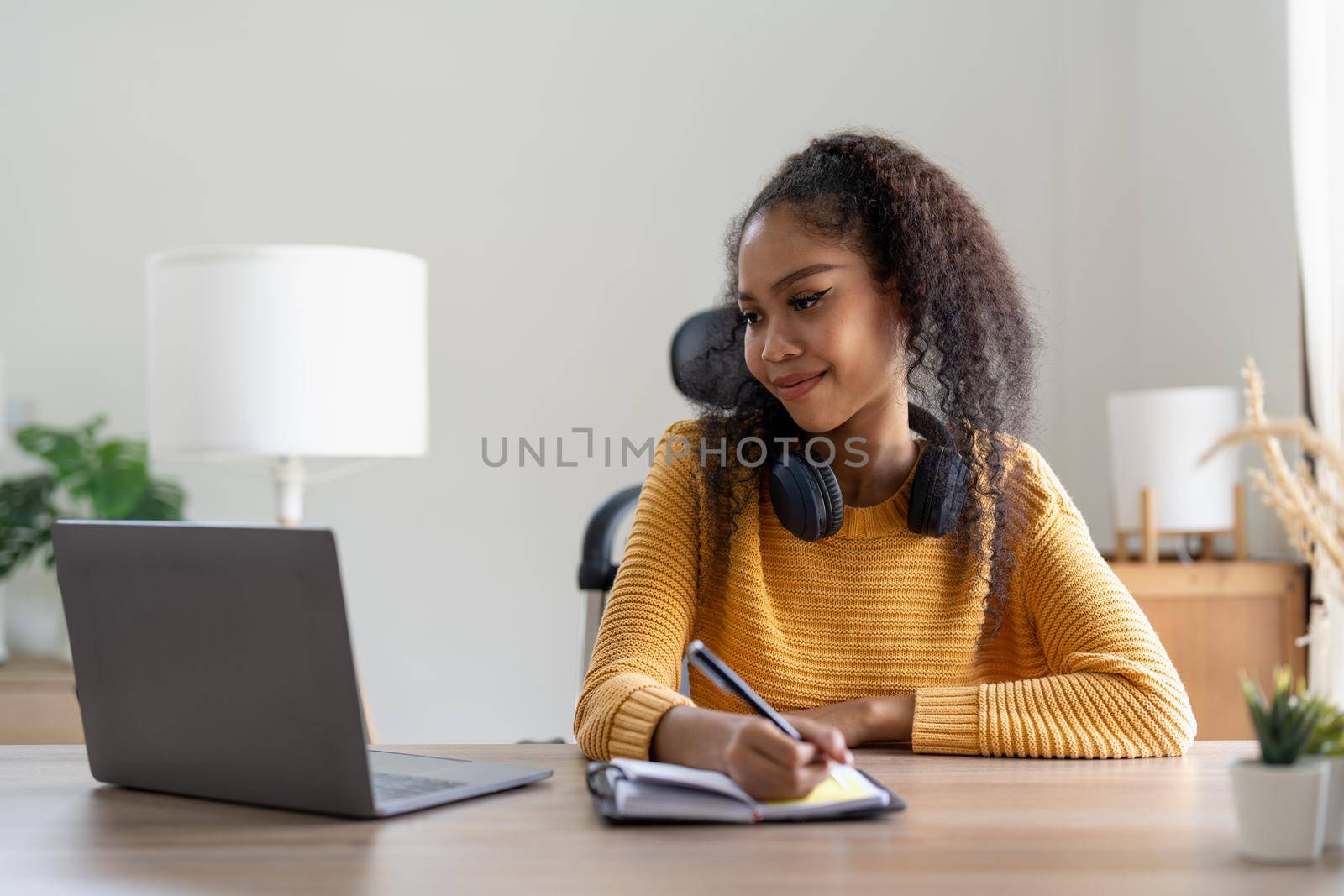 Young woman using laptop computer at office. Student girl working at home. Work or study from home, freelance, business, lifestyle concept.