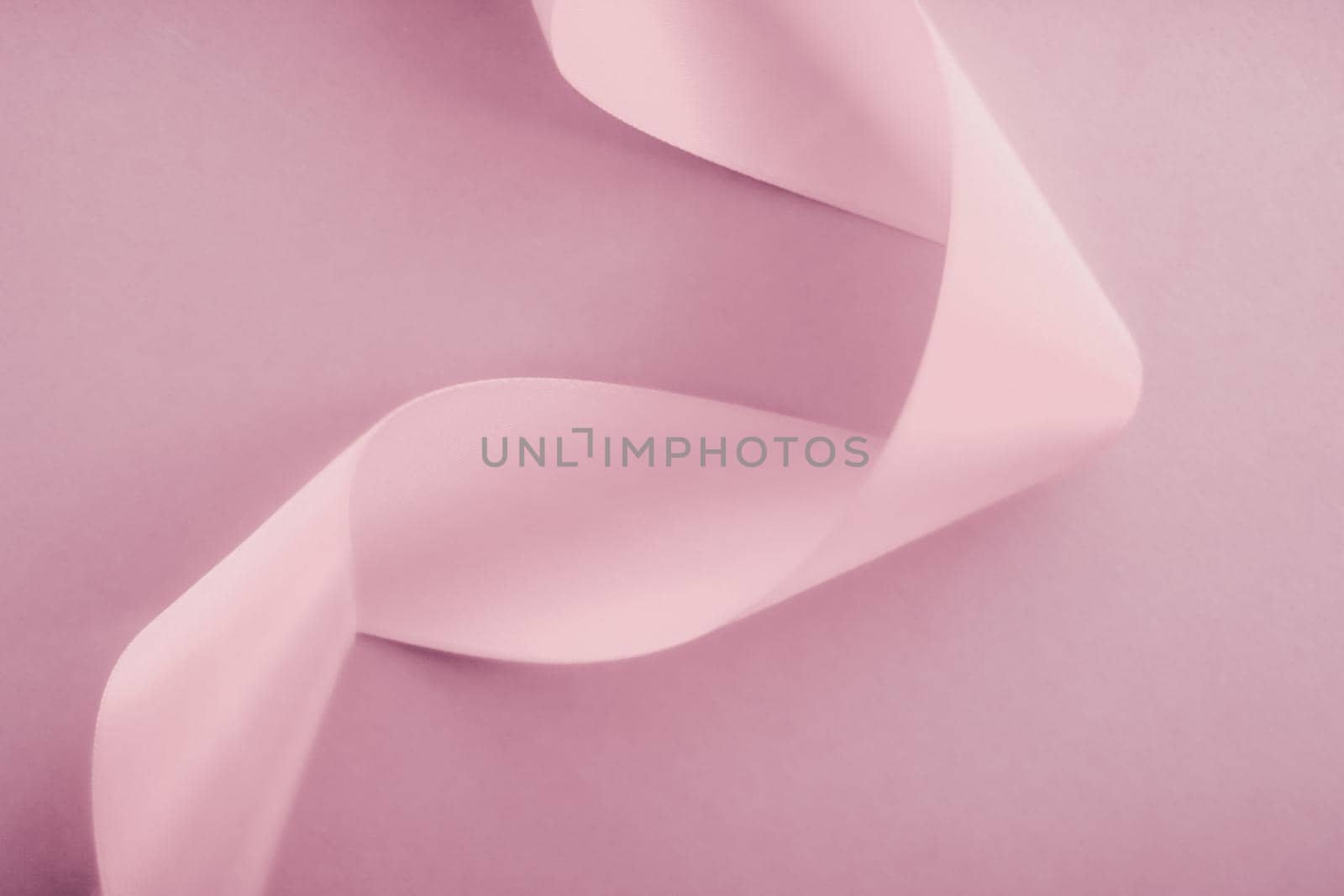 Branding, holidays and luxe brands concept - Abstract silk ribbon on blush pink background, exclusive luxury brand design for holiday sale product promotion and glamour art invitation card backdrop