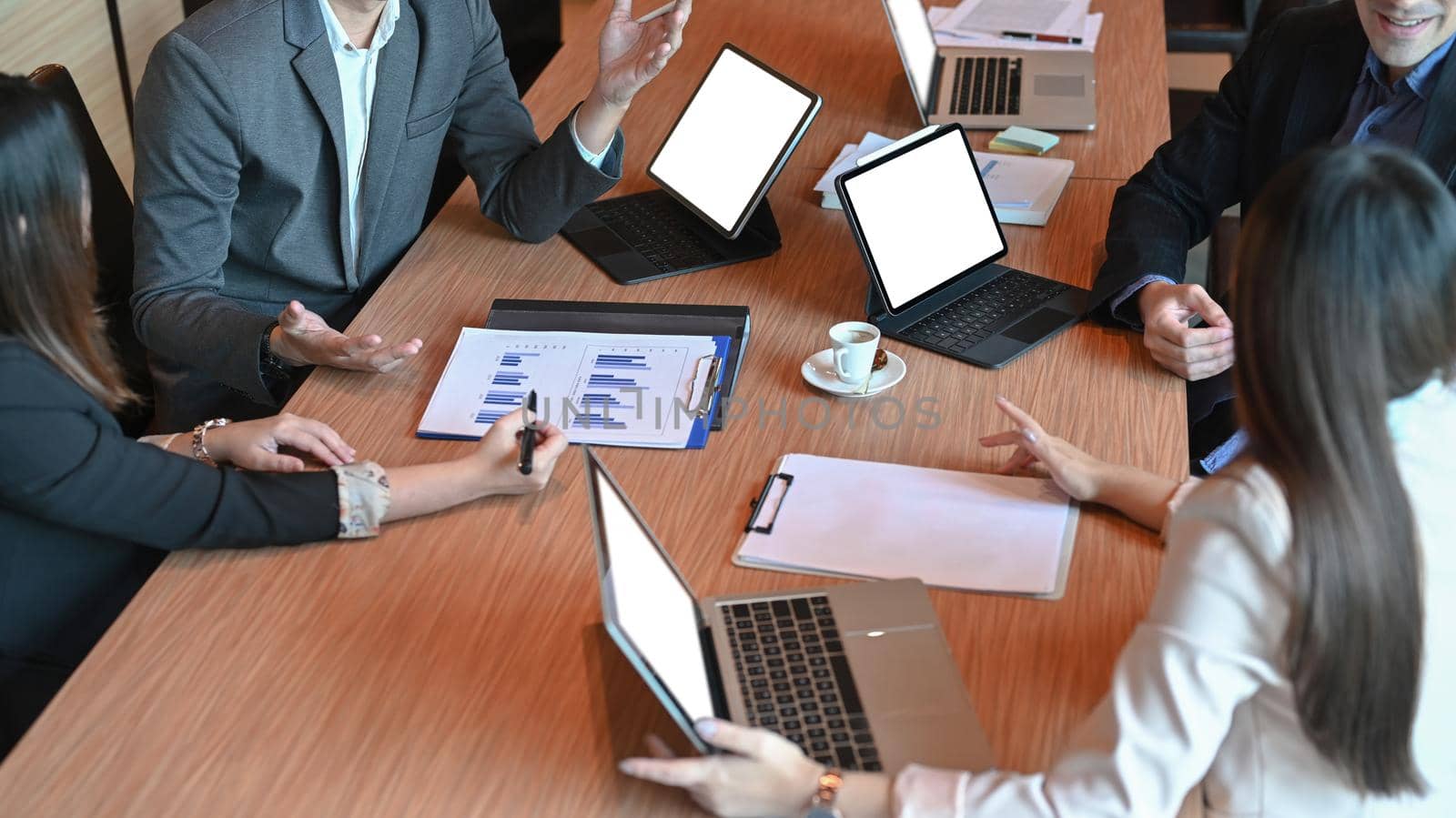 Diverse business people planning and discussing financial strategy in boardroom. by prathanchorruangsak