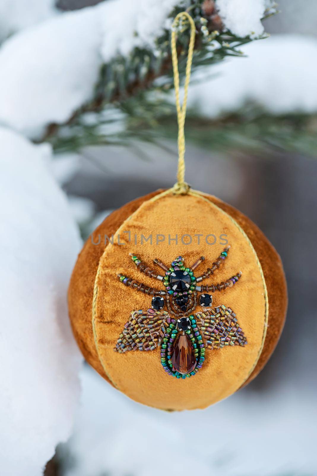 Hanging orange Christmas ball on spruce and over blurred background by anytka