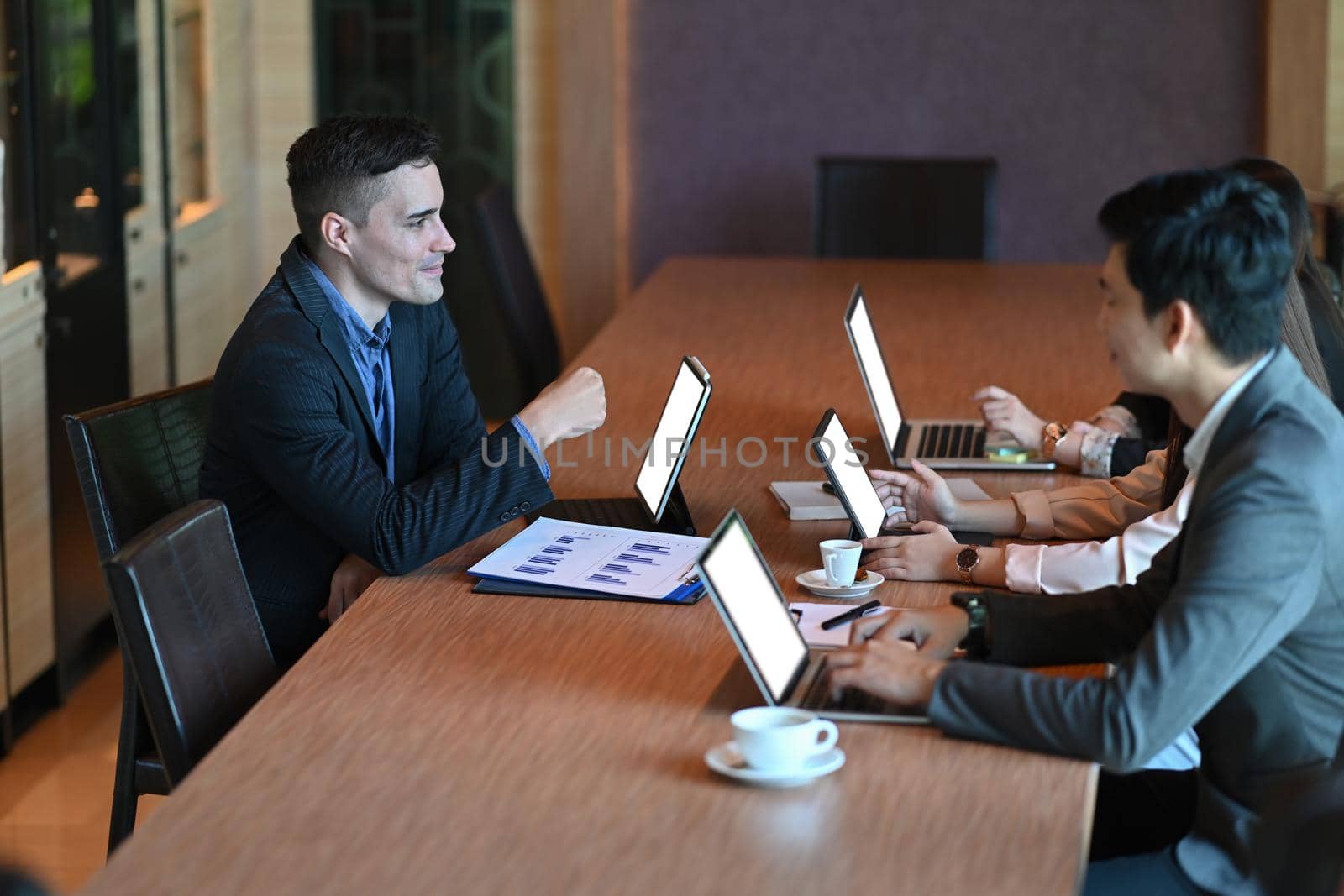 Group of businesspeople brainstorming and planning financial strategy in office.