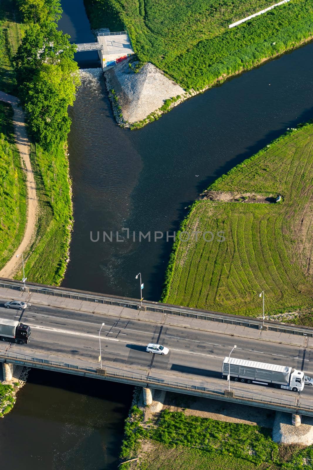 Aerial view of a bridge over a river with several cars in the morning on a summer day