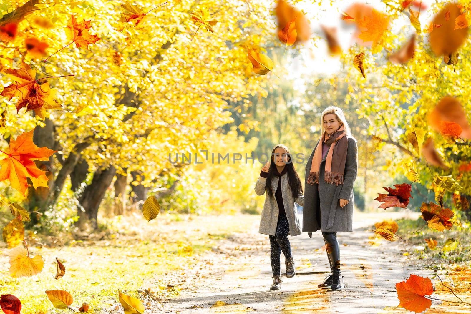 Happy family on autumn walk Mother and daughter walking in the Park and enjoying the beautiful autumn nature. High quality photo