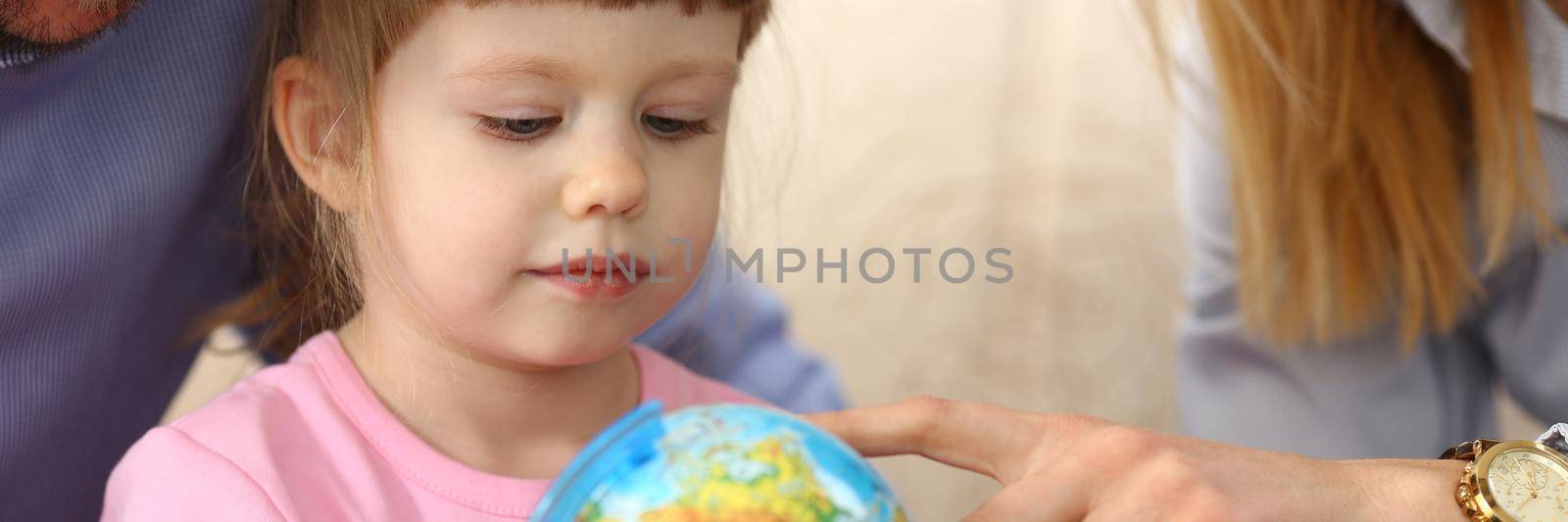 Parents show world globe to child. Traveling with kids concept